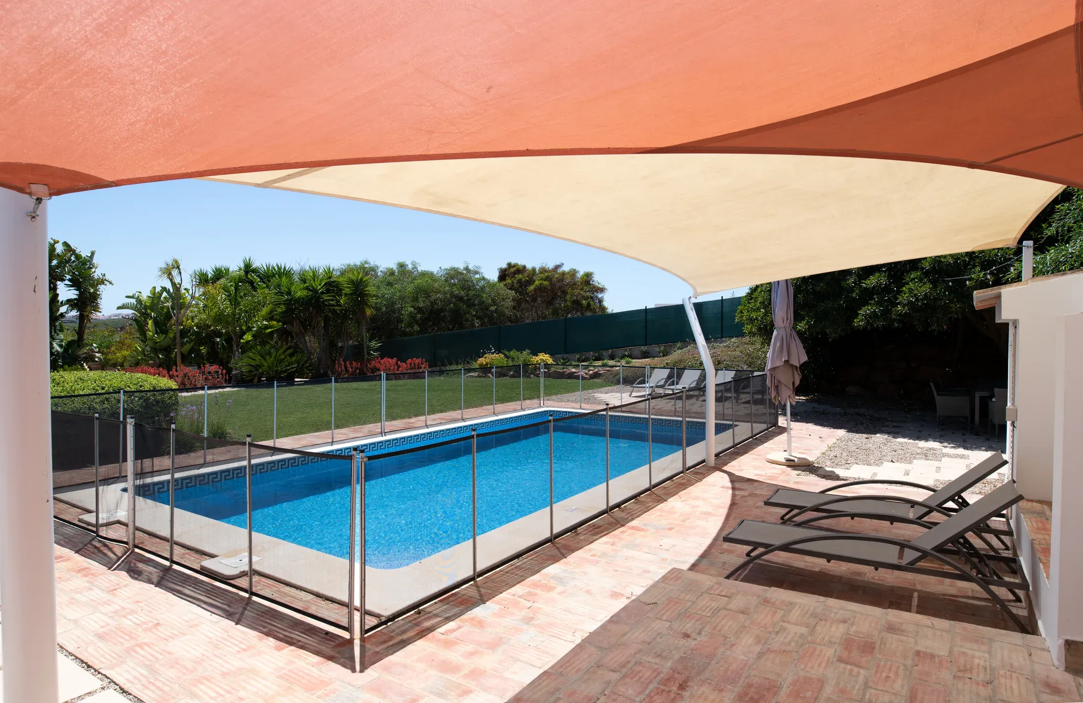 A residential swimming pool enclosed by a mesh safety fence, the style of barrier Arizona law regulates